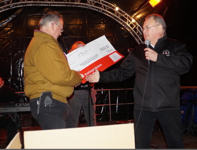 Vorstandsmitglied Dieter Klauck von den Flughafenfreunden Saarbrücken e. V. überreicht einen symbolischen Spendenscheck in Höhe von 500 Euro an Klaus Port