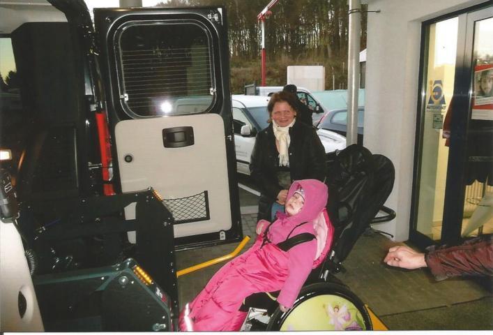 Kiara in ihrem Rollstuhl mit Mama Beata an der Rollstuhlrampe des neuen Fahrzeuges