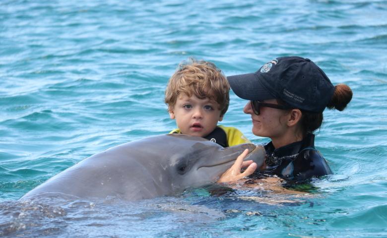 Das Foto zeigt den 5jährigen Raoul bei seiner ersten Delfintherapie in Curacao mit 'seinem Delfin Nubia' und einer Therapeutin