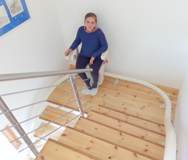 Enid-Mia freut sich über ihren neuen Treppenlift, mit dem sie jetzt ohne Hilfe die Treppe im Wohnhaus bewältigen kann (Bildrechte: Klaus Port)